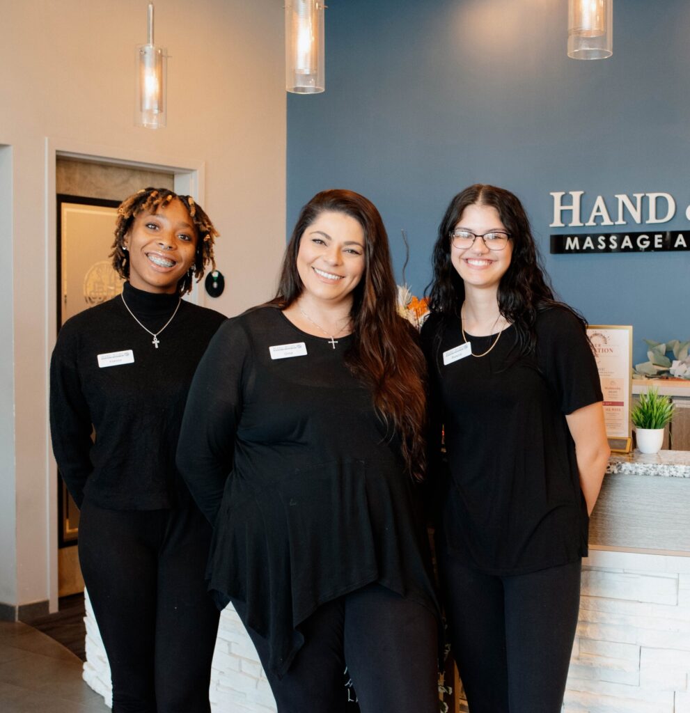 Three employees standing in front of front desk lobby