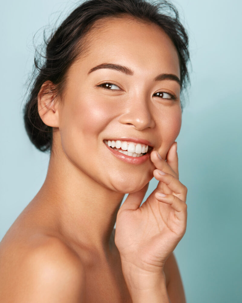 A woman with dark eyes and luminous skin and a bright white smile.