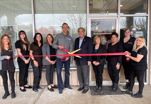 Hand & Stone Franchise owner and employees at red ribbon cutting ceremony